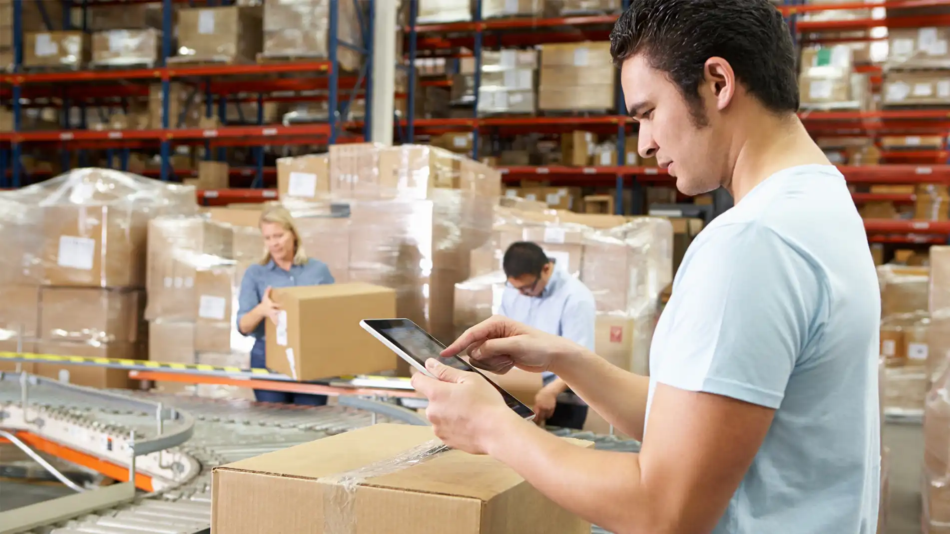 Image of a person using a handheld device standing over a box.