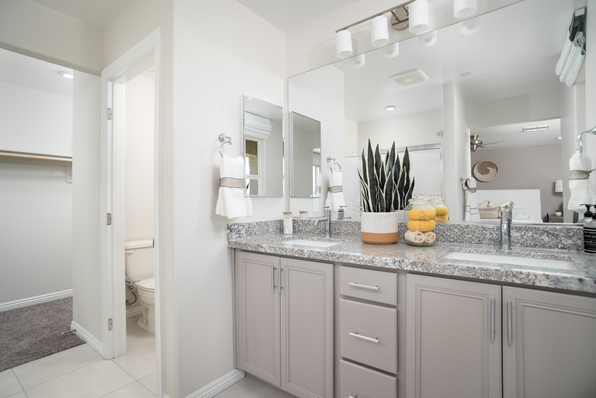 bathroom with double vanities and mirror