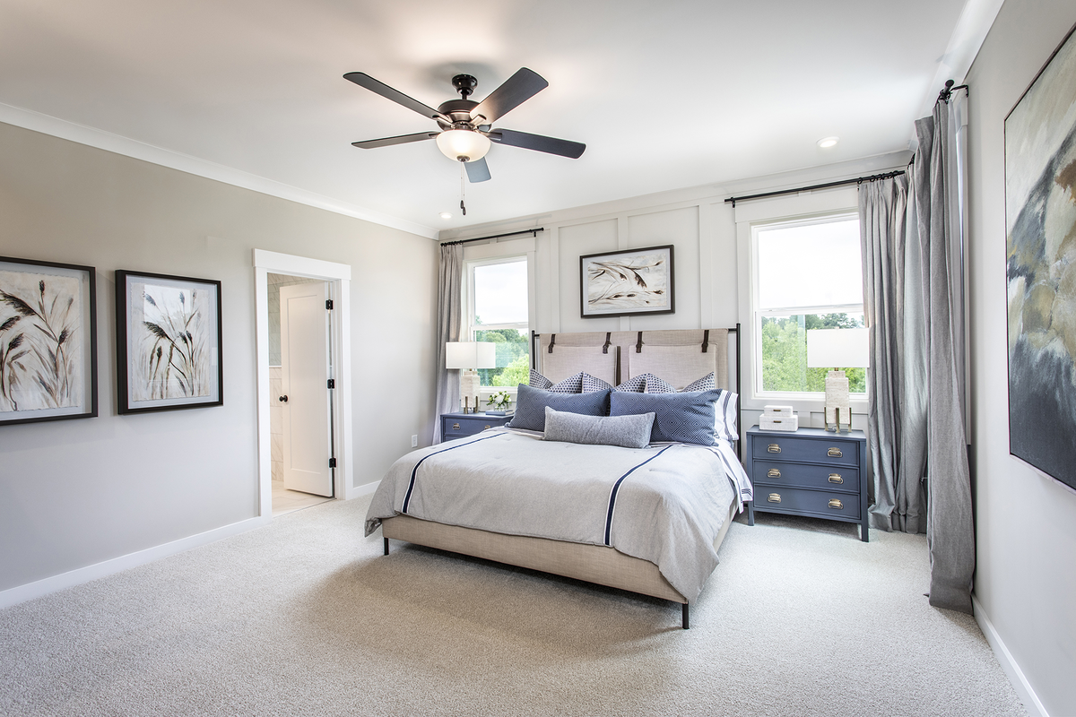 primary bedroom with windows and carpet