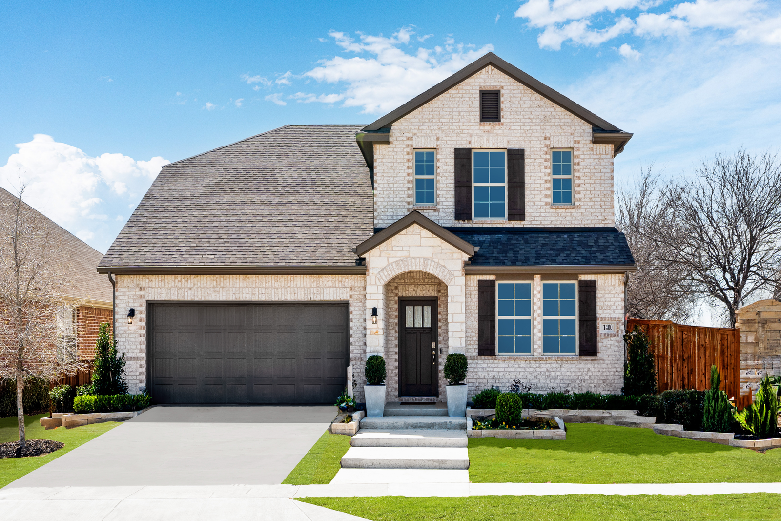 stone and brick exterior with tree in front yard