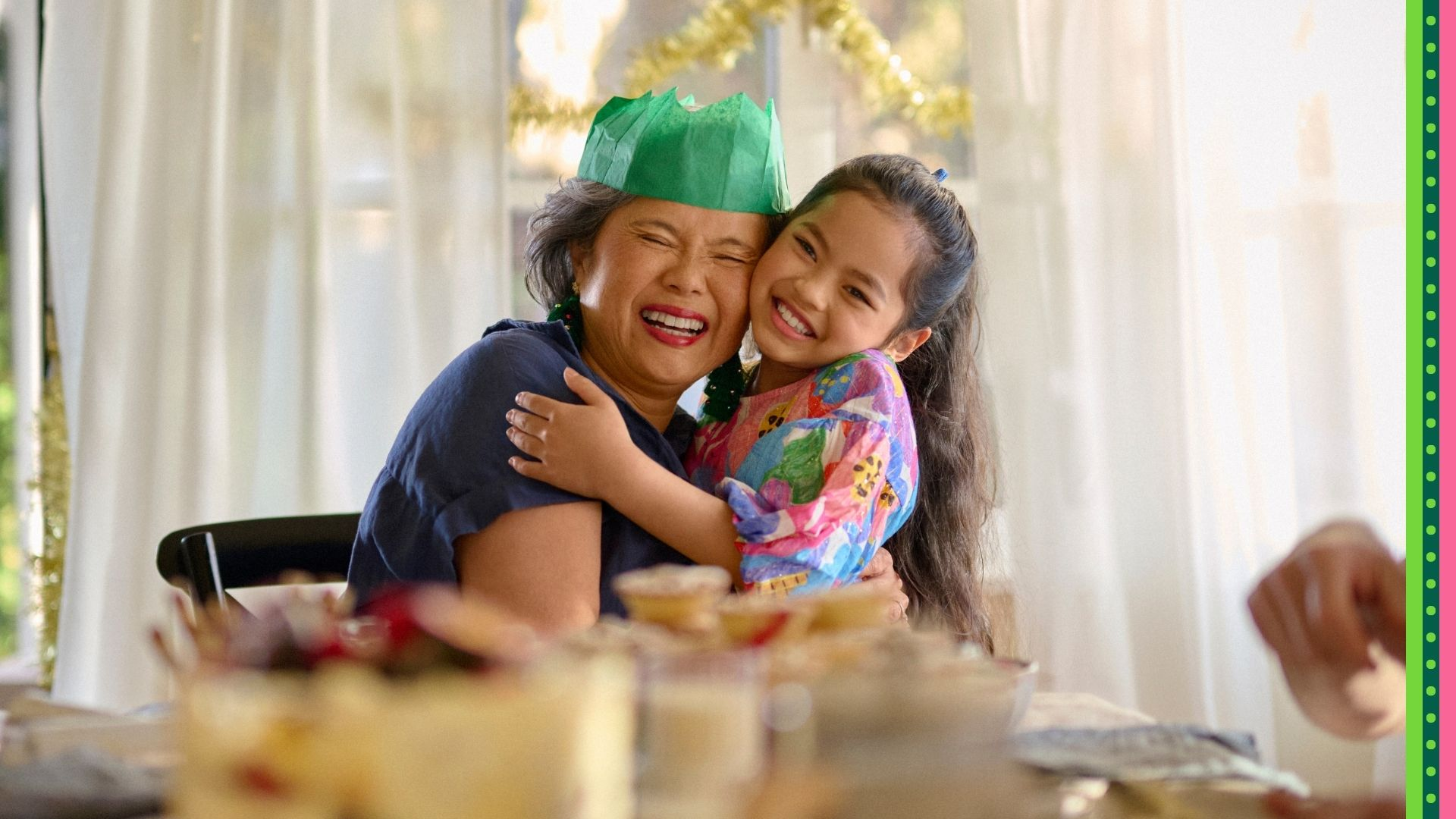 Nanna and granddaughter embracing in a hug, amongst a joyful family Christmas meal