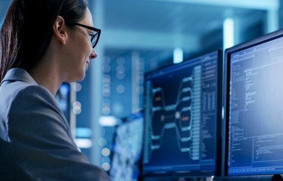 Woman working at a computer in a server room