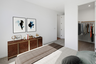 bedroom with a brown wooden dresser, a walk-in closet, and a spacious bed