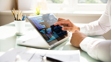 Person using a tablet to look at a dashboard of metrics