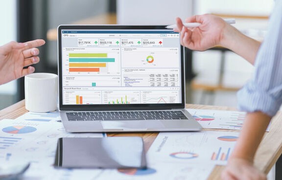 Business people reviewing data dashboard on laptop