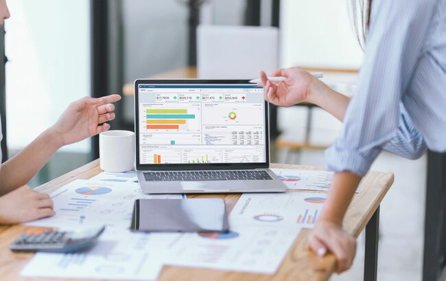 Business people reviewing data dashboard on laptop