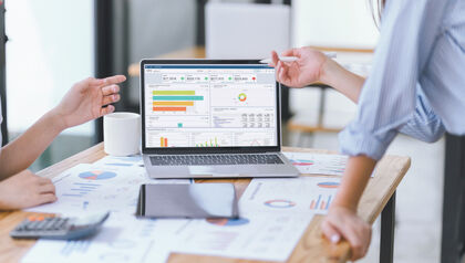 Business people reviewing data dashboard on laptop