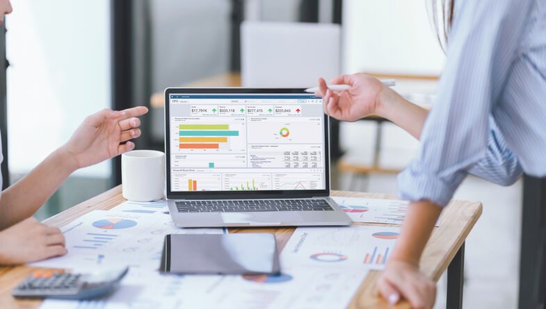 Business people reviewing data dashboard on laptop