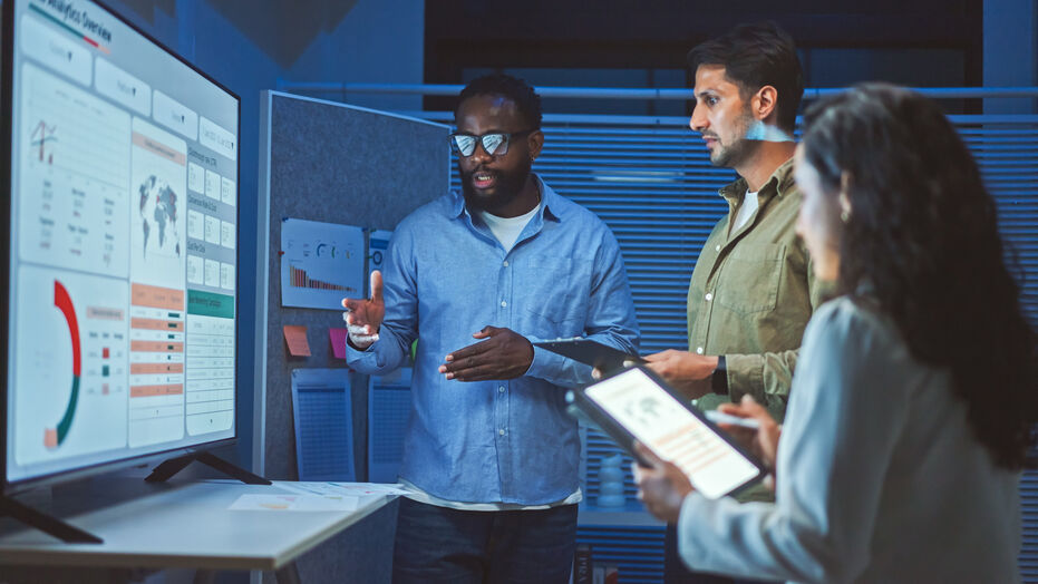 Data analytics team reviewing graphs on computer