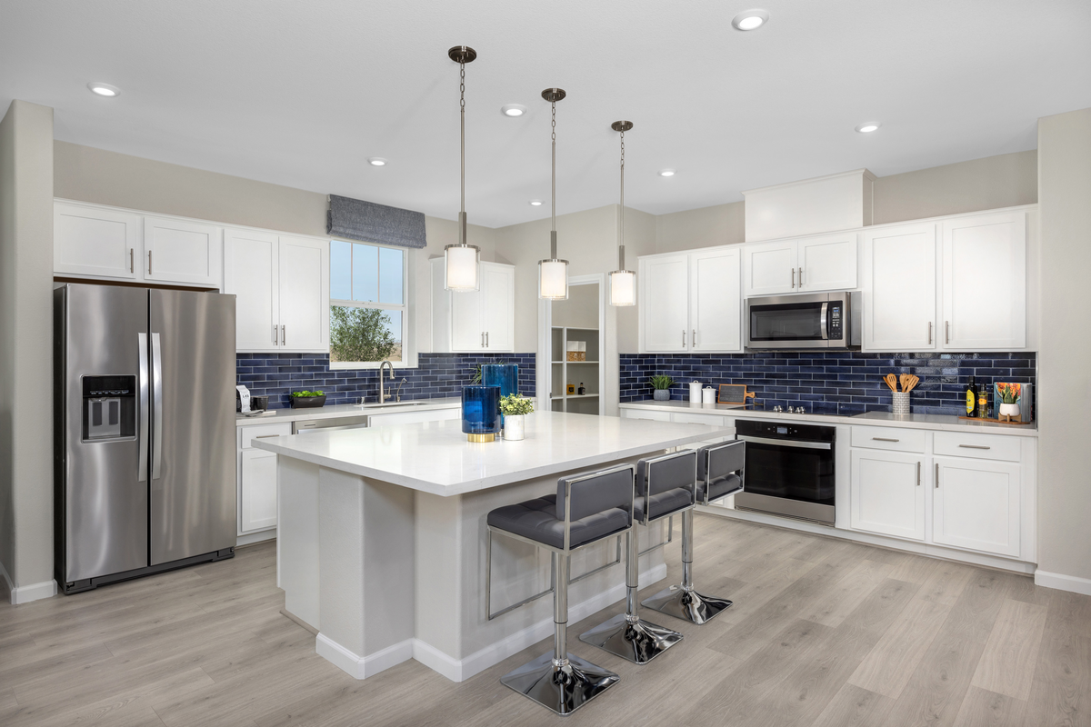 kitchen with blue backsplash and white cabinets