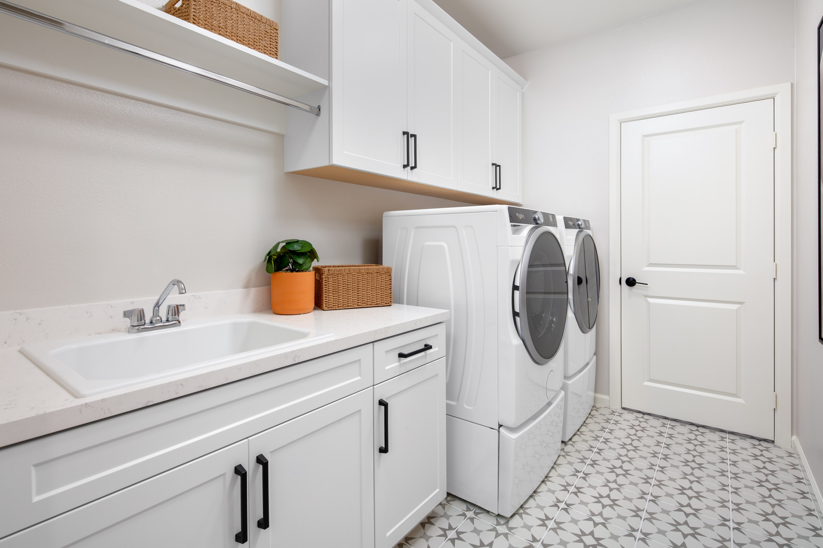 laundry room with tile floors and white cabinets