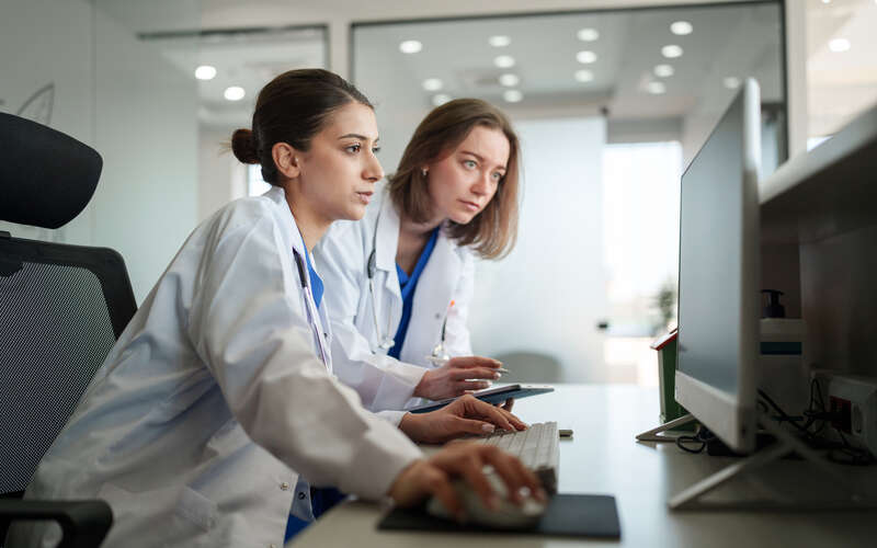 two female doctors review case on computer
