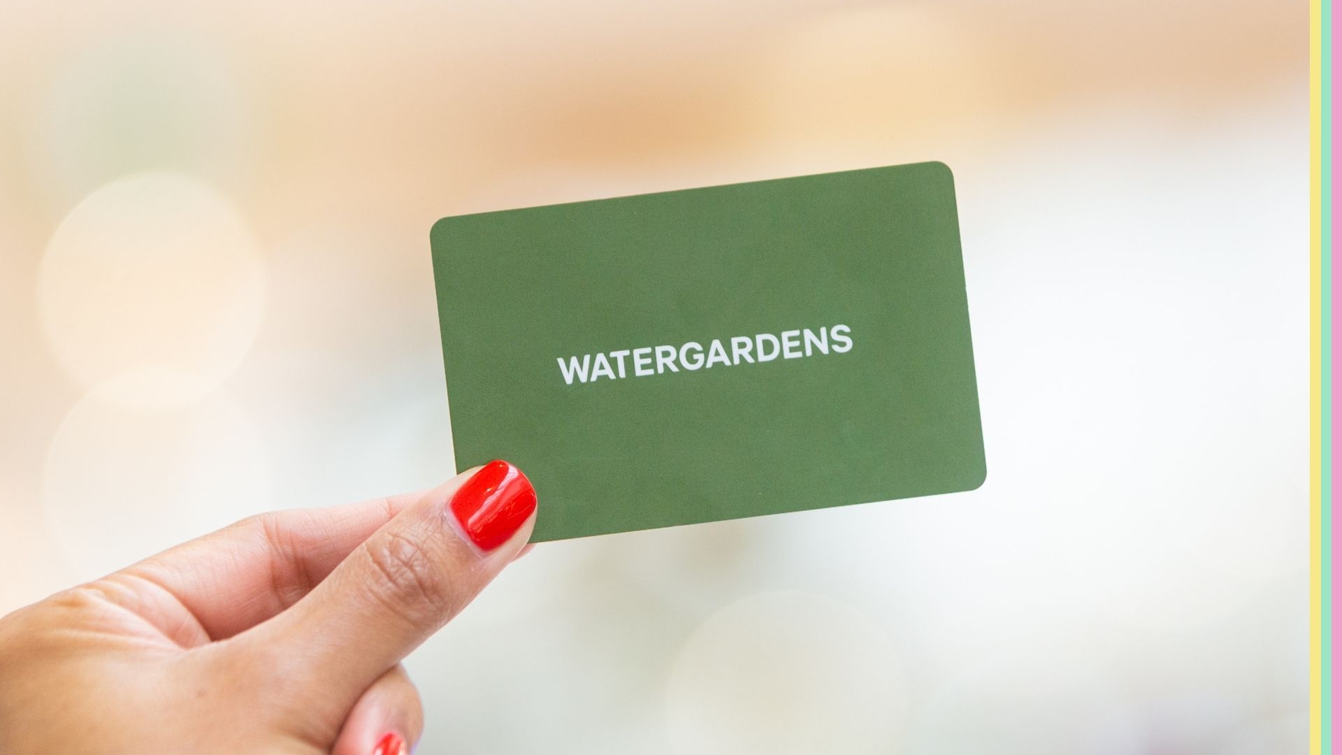 Woman's hand holding a watergardens gift card