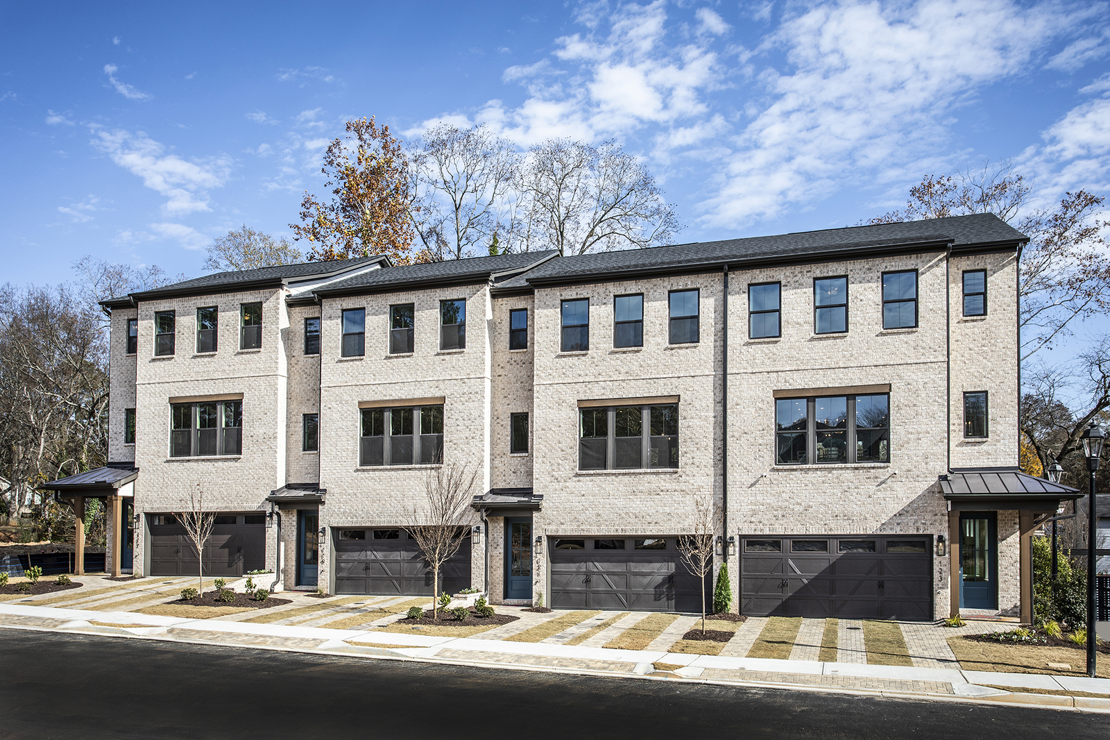 front of townhome building withlight brick and dark garages