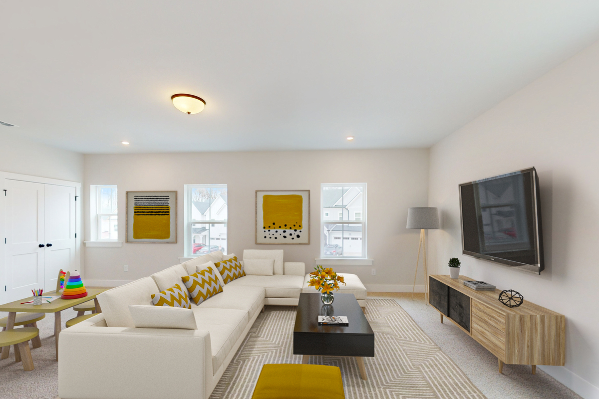 bright loft with a couch facing a TV and art table