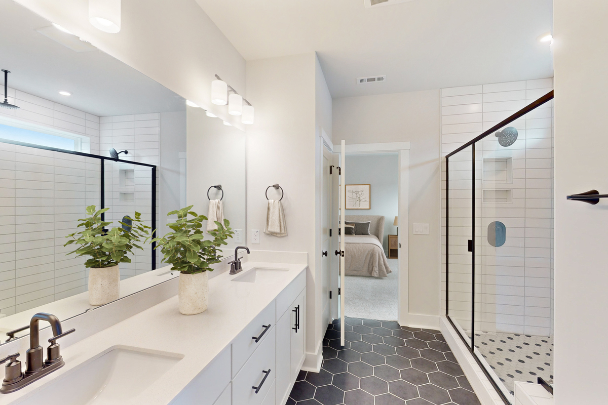 primary bath with double sinks and white cabinets