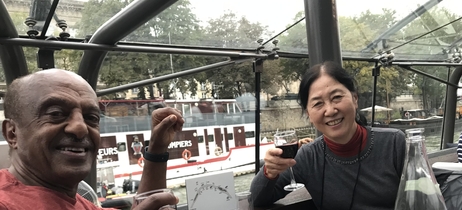 Fumie and Ahmed raise their glasses at a meal in France