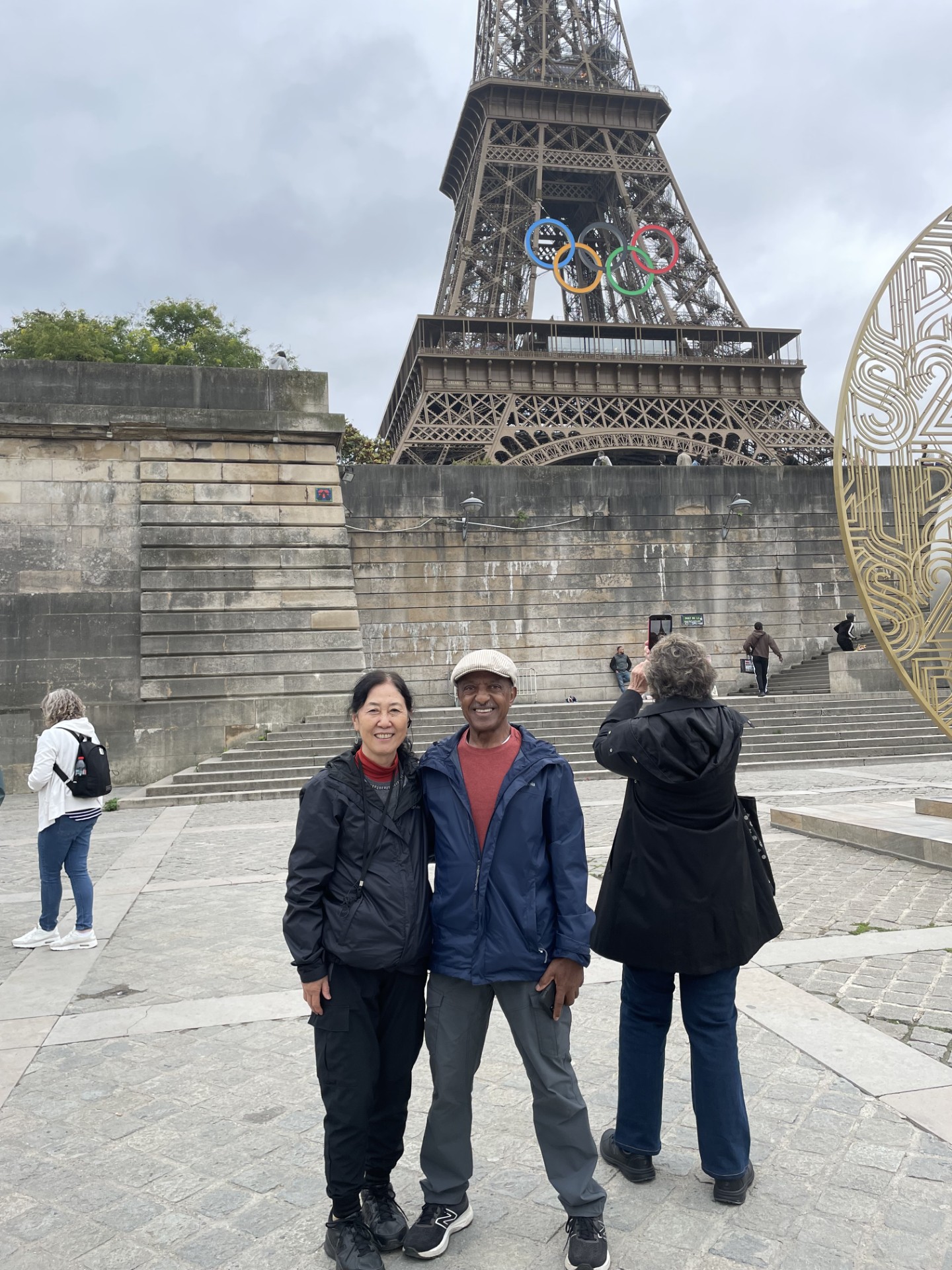 Fumie and Ahmed stand in front of the Eiffel Tower
