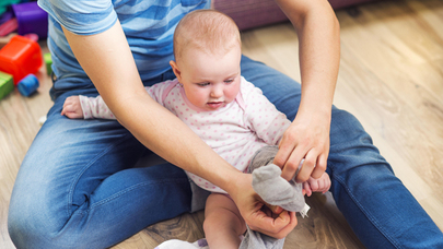 Parent putting socks on baby.