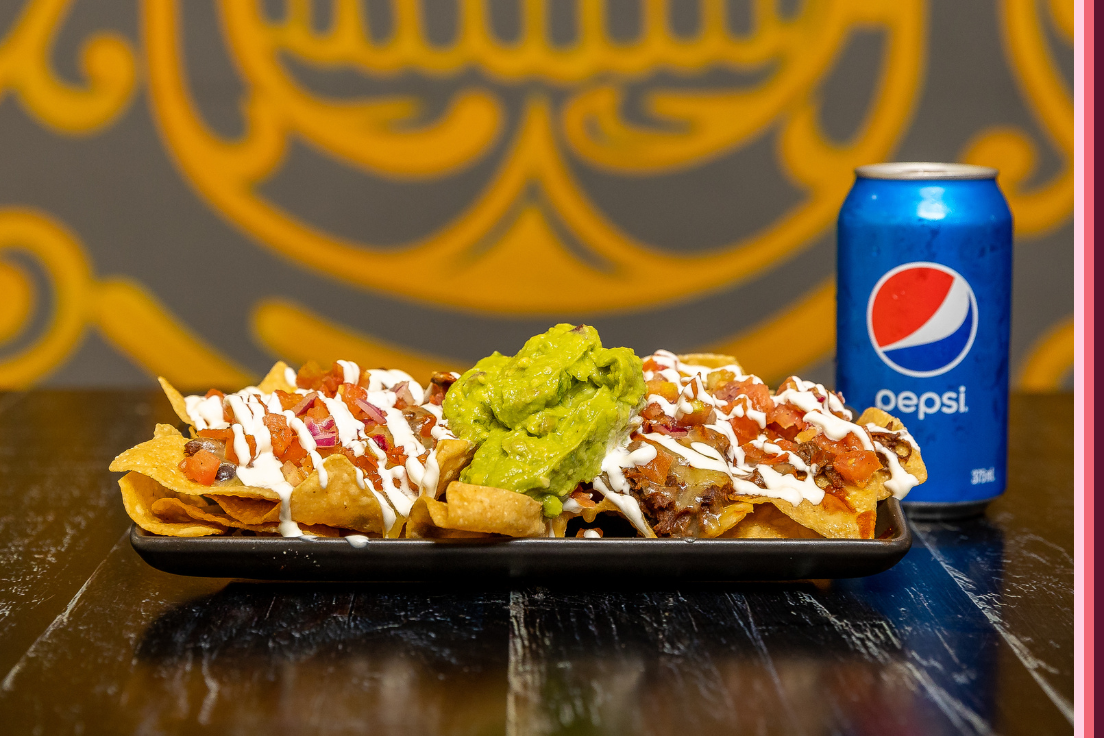 Plate of nachos with a can of Pepsi from Burrito Bar