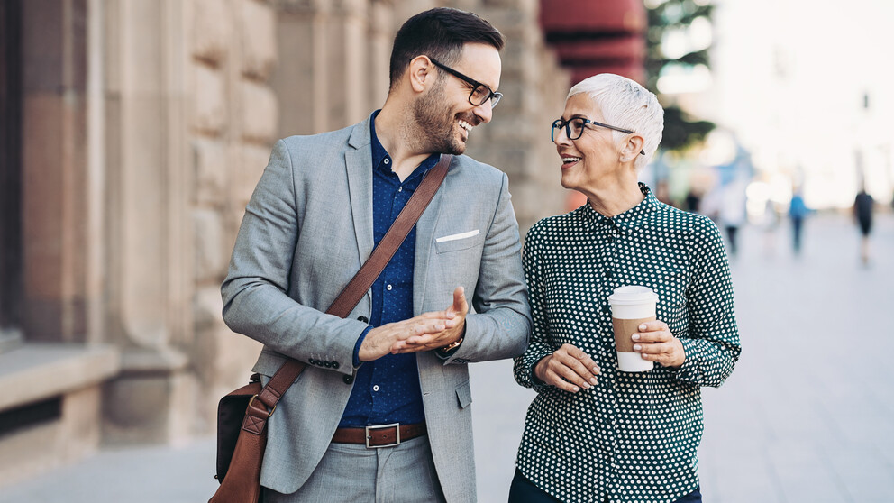 Man and woman wearing glasses chatting outside