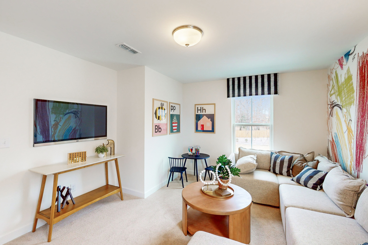 room with colorful wallpaper and a large sectional