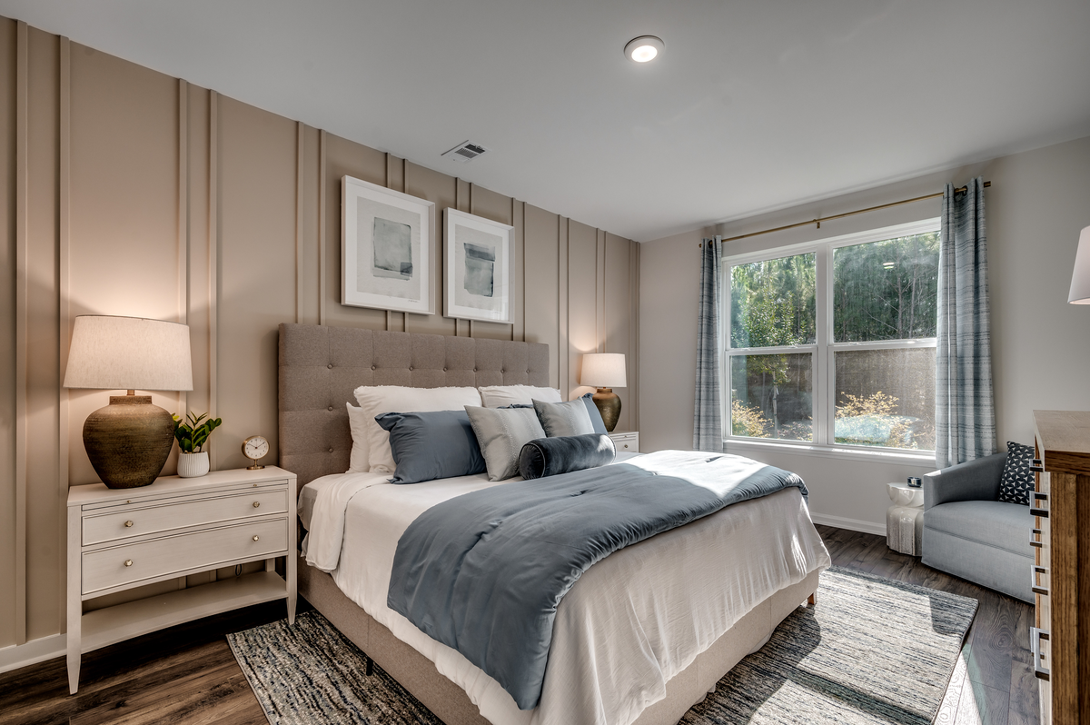 large windows, tan accent wall and hardwood floors