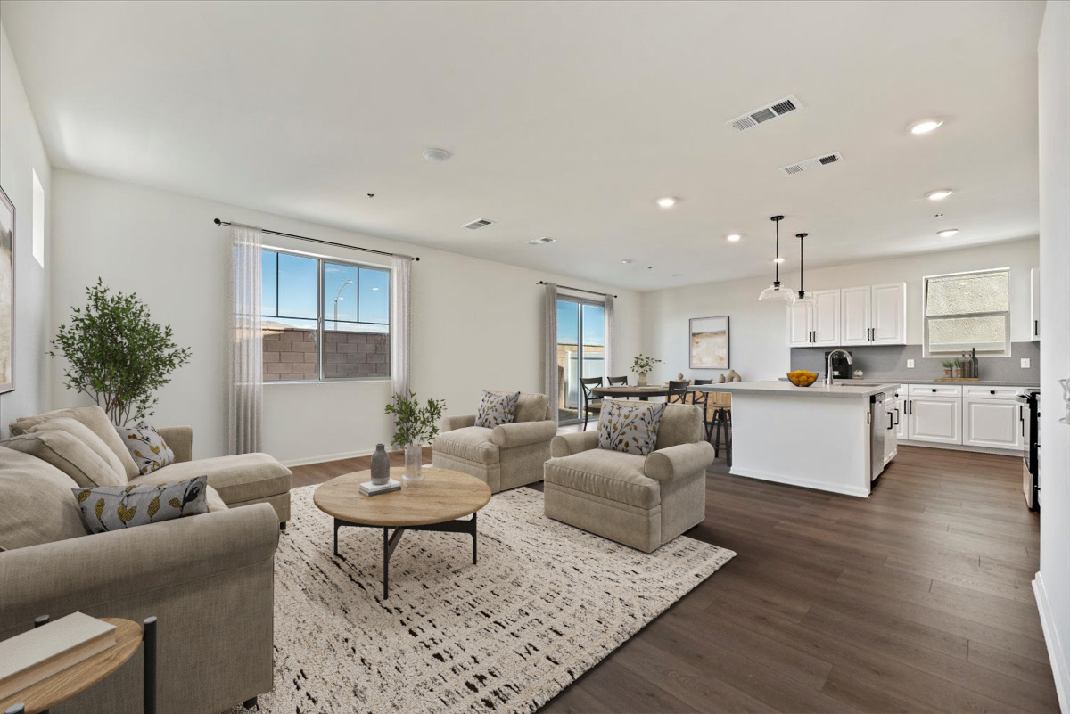 great room with a couch and coffee table leading to the dining room and kitchen