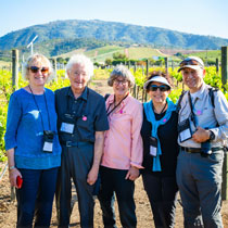 A group of five people posing in the vineyards of Casablanca Valley with scenic green hills in the background.
