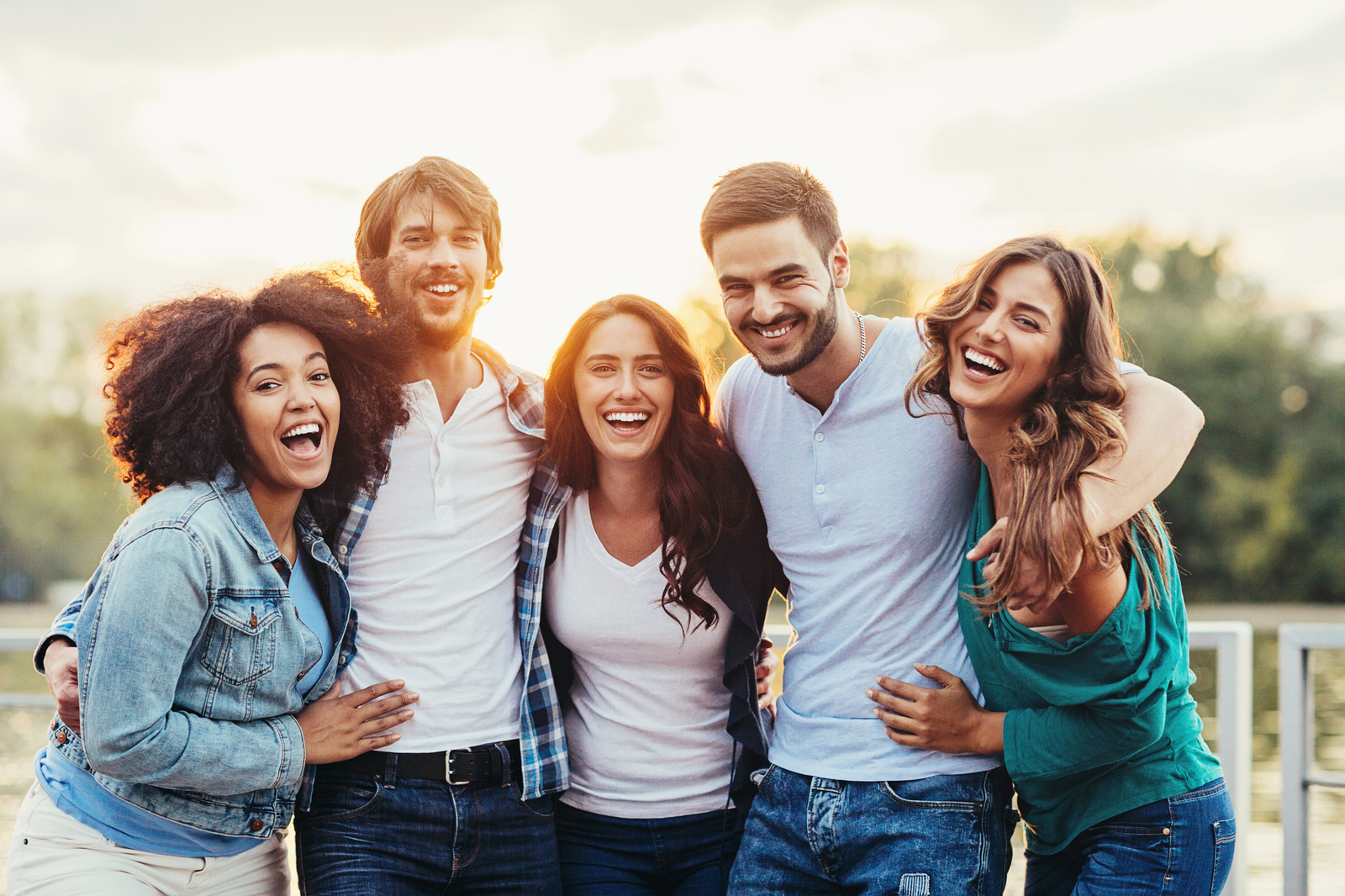 friends with their arms around each other smiling