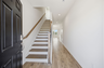 entryway with oak tread stairs with iron railing and wood floors