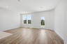 great room with wood floors, white walls, and large windows