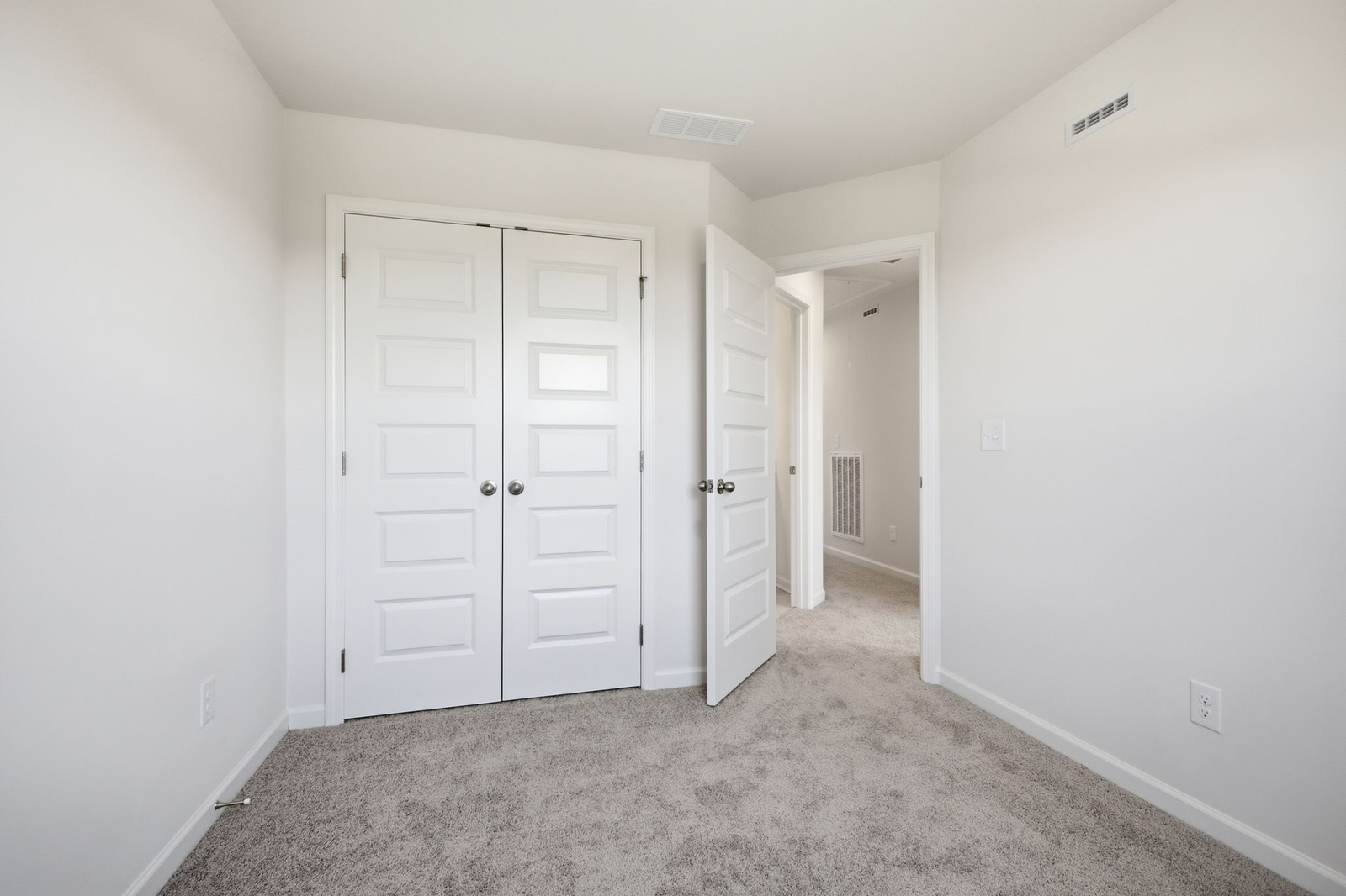 secondary bedroom with carpet, large windows, and double door closet