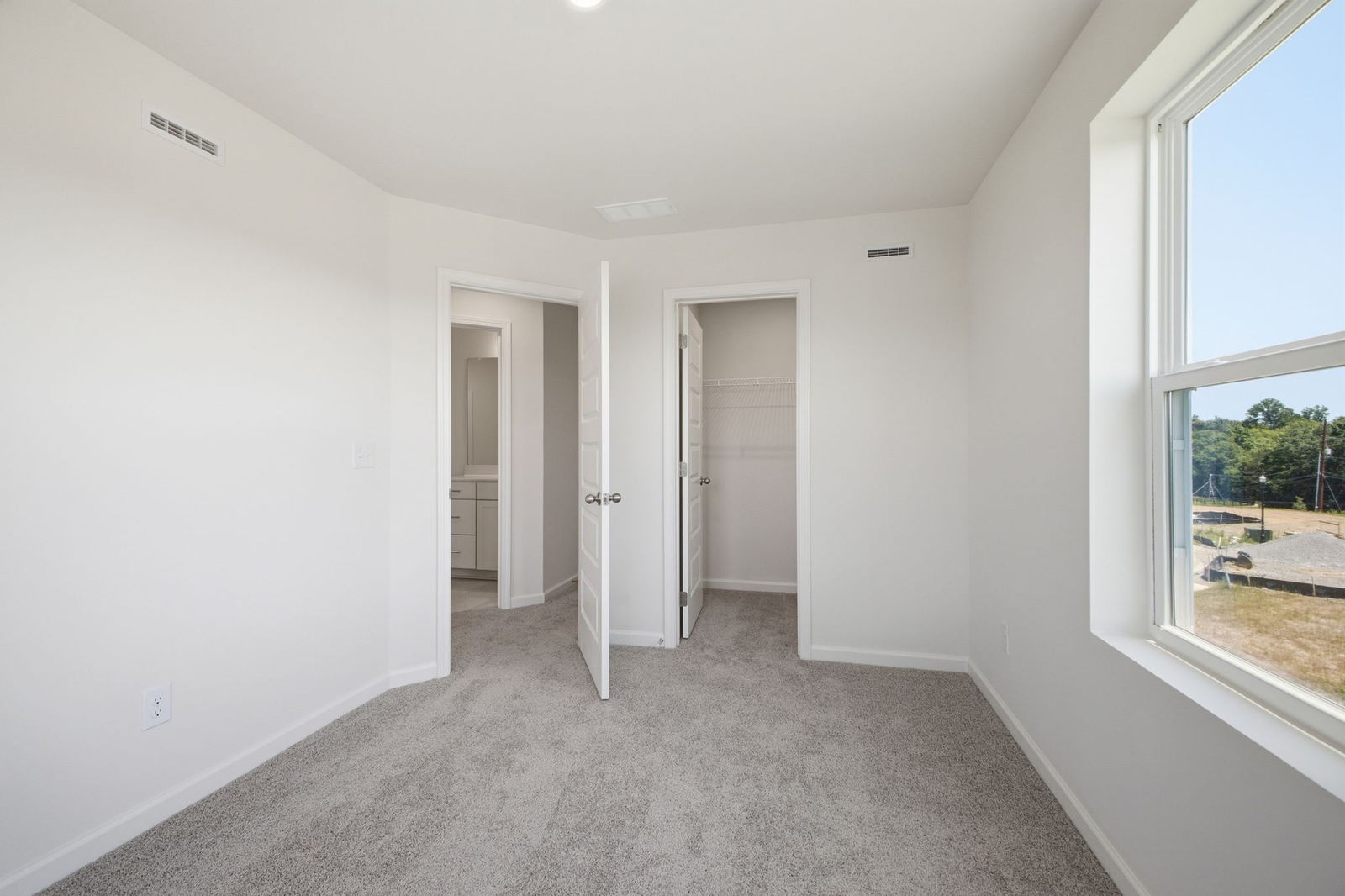 secondary bedroom with carpet, large windows, and double door closet