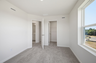 secondary bedroom with carpet, large windows, and double door closet