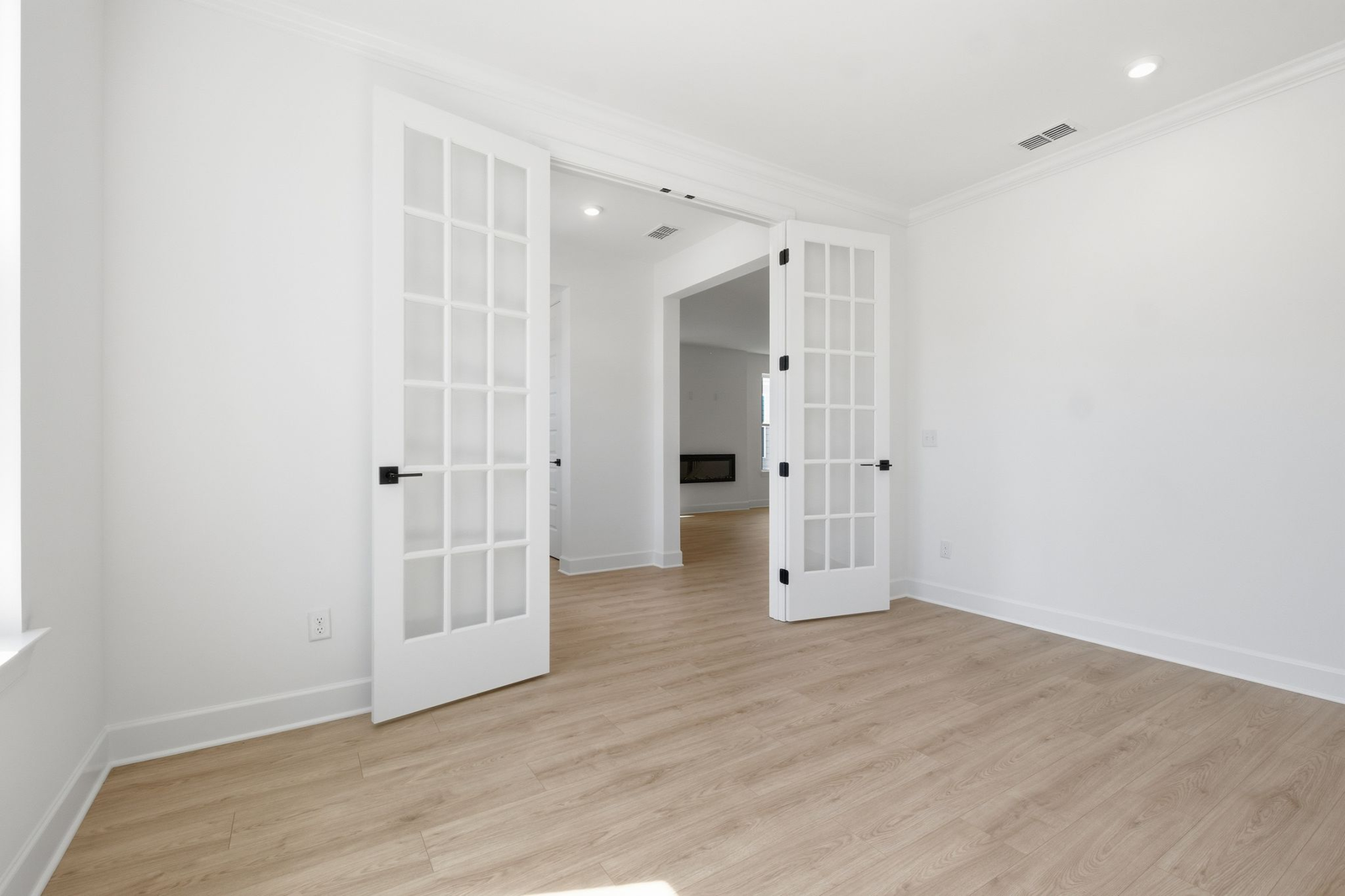 study with wood floors, large windows, and french doors