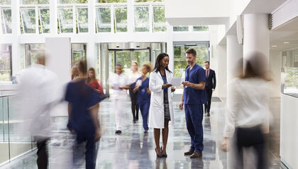 Hospital staff in lobby with people in motion