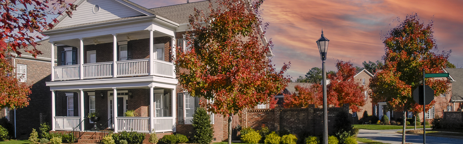 A colonial house in a neighborhood surrounded by trees