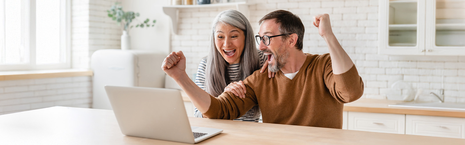 A happy couple celebrating in their kitchen