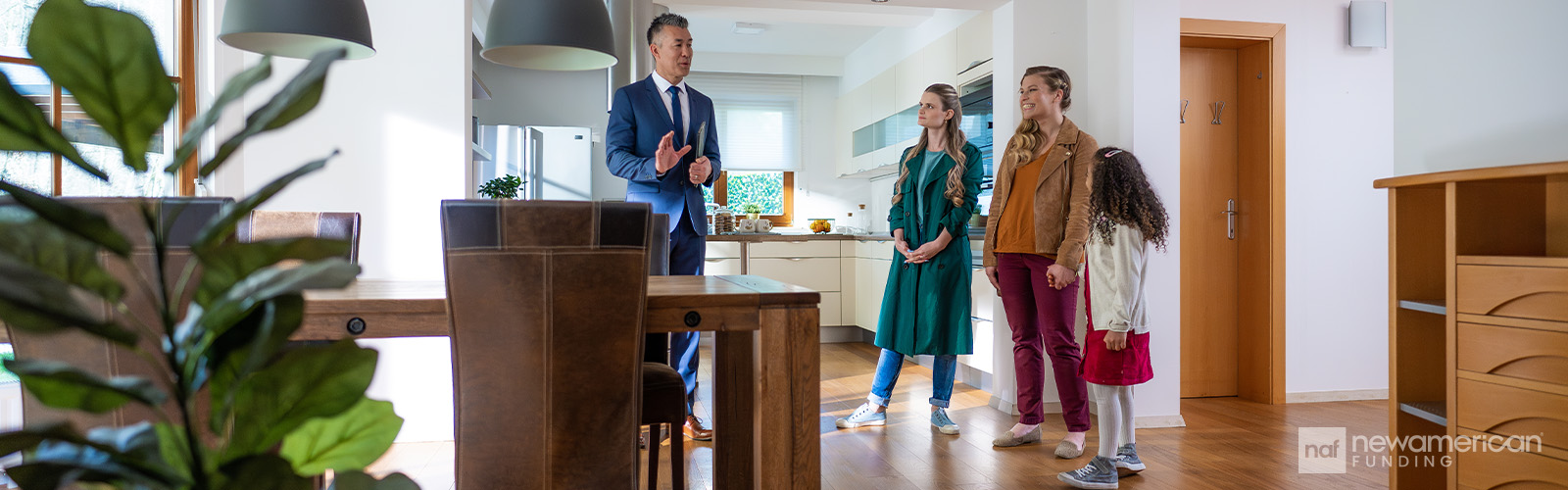 A real estate agent talking to a family inside of a home.