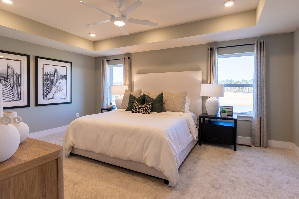 primary suite with a box ceiling and carpet