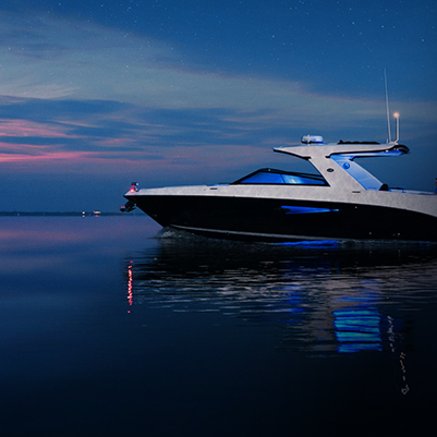 Powerboat with onboard Fathom e-power system at anchor on calm waters at blue hour