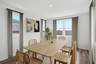 open-concept space with a large oak dining table, wooden chairs, and beige rug