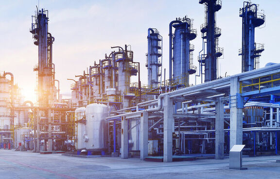 Oil refinery plant against a blue sky with wispy clouds 