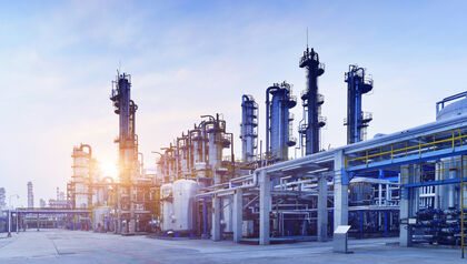 Oil refinery plant against a blue sky with wispy clouds 