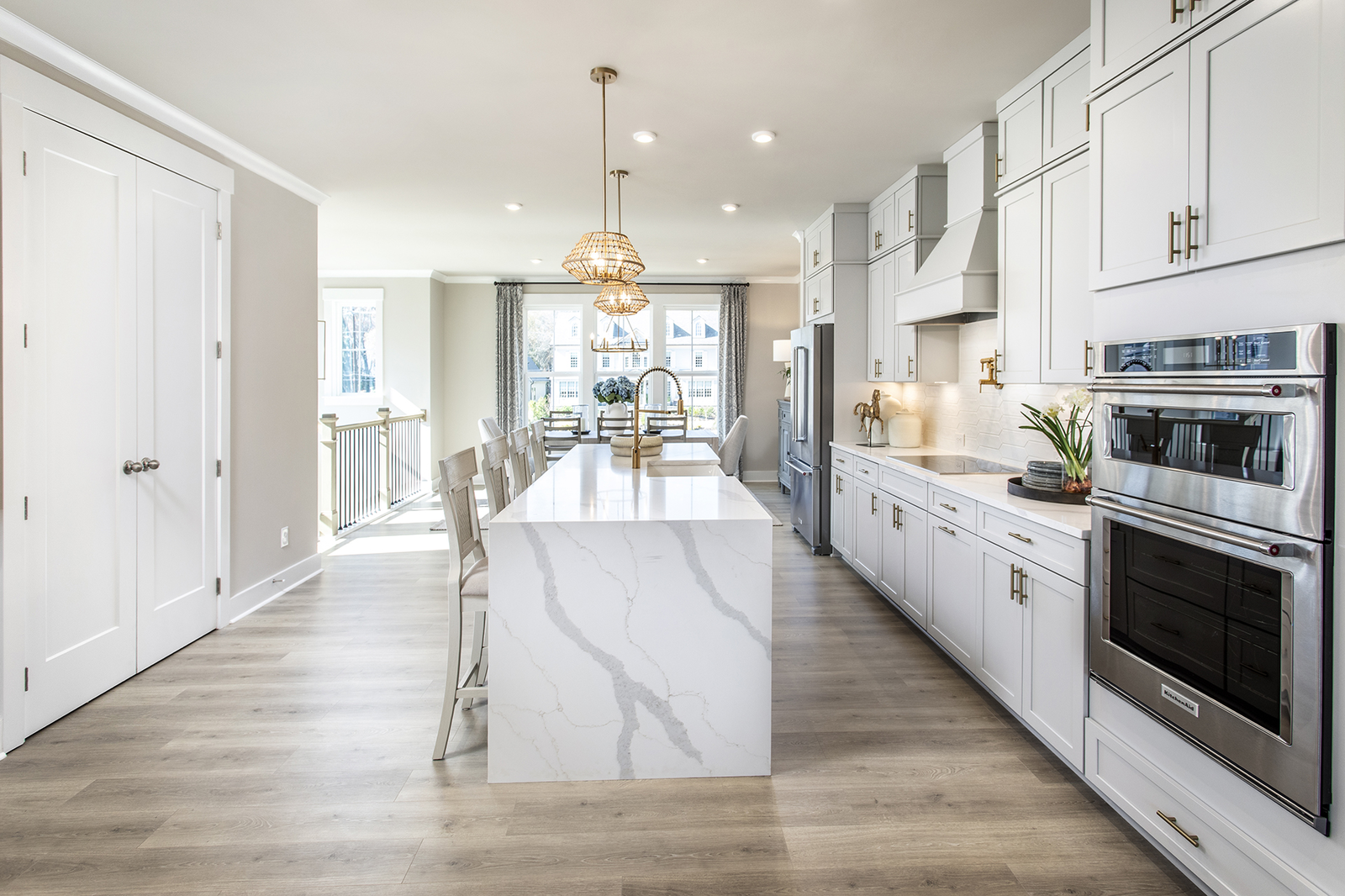 kitchen with waterfall quartz counter on the island and white cabinets 
