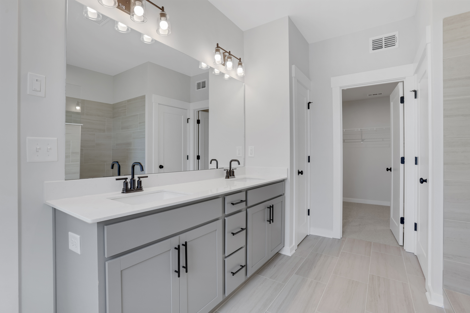 primary bathroom with gray cabinets and tile flooring