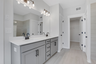 primary bathroom with gray cabinets and tile flooring 
