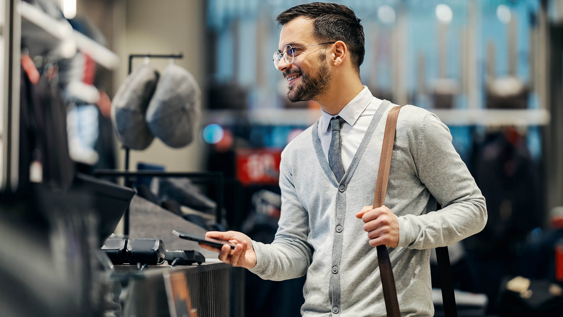 Man instore using cell phone to purchase