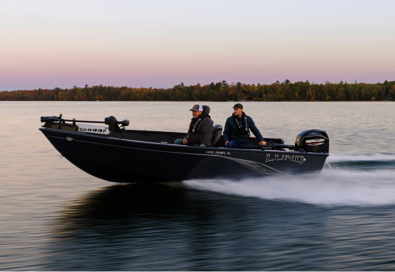 Black RIB with onboard Fathom e-power system speeding across a lake before sunrise